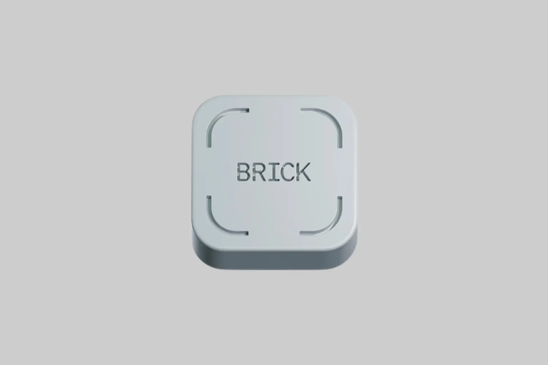 Brick phone distraction blocker, a small gray physical NFC device, shown next to a smartphone on a clean desk surface.