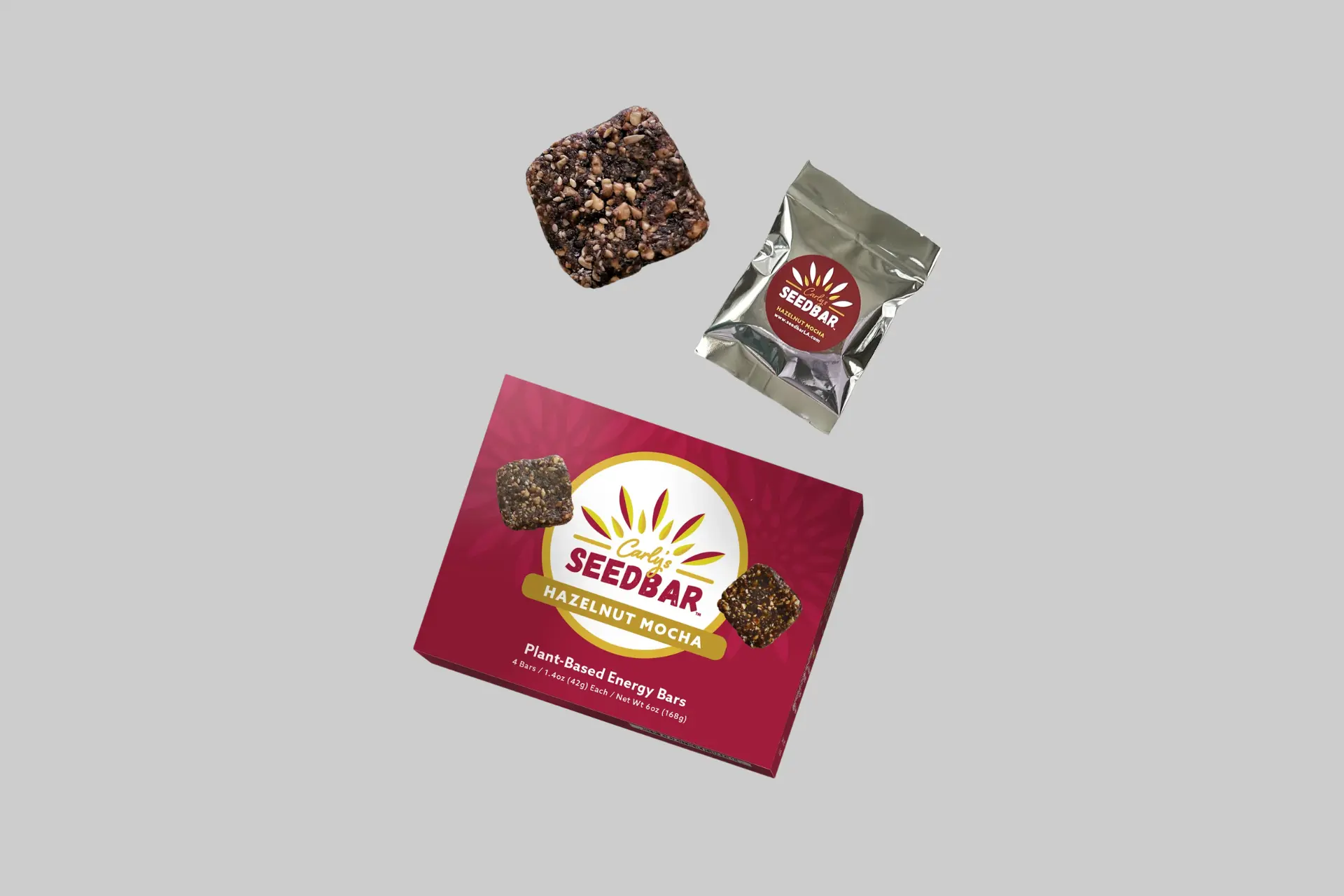 A 4-pack box of Carly's SEEDBAR Hazelnut Mocha 1.4oz bars on a beige background, showing the clean label packaging with toasted hazelnuts and espresso bits visible.