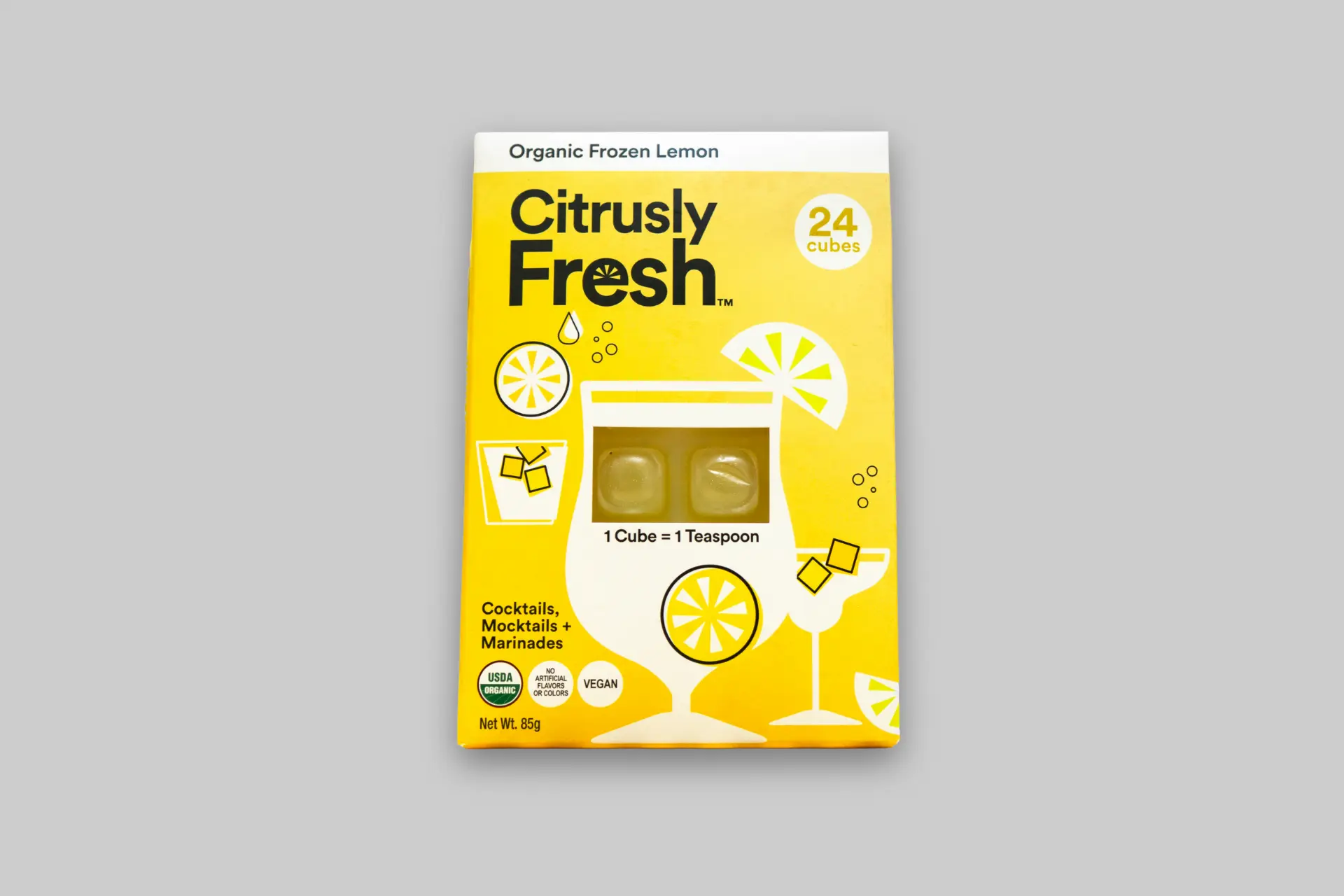 A close-up image of Citrusly Fresh organic frozen citrus cubes in a glass, with fresh fruit in the background. - Product Review