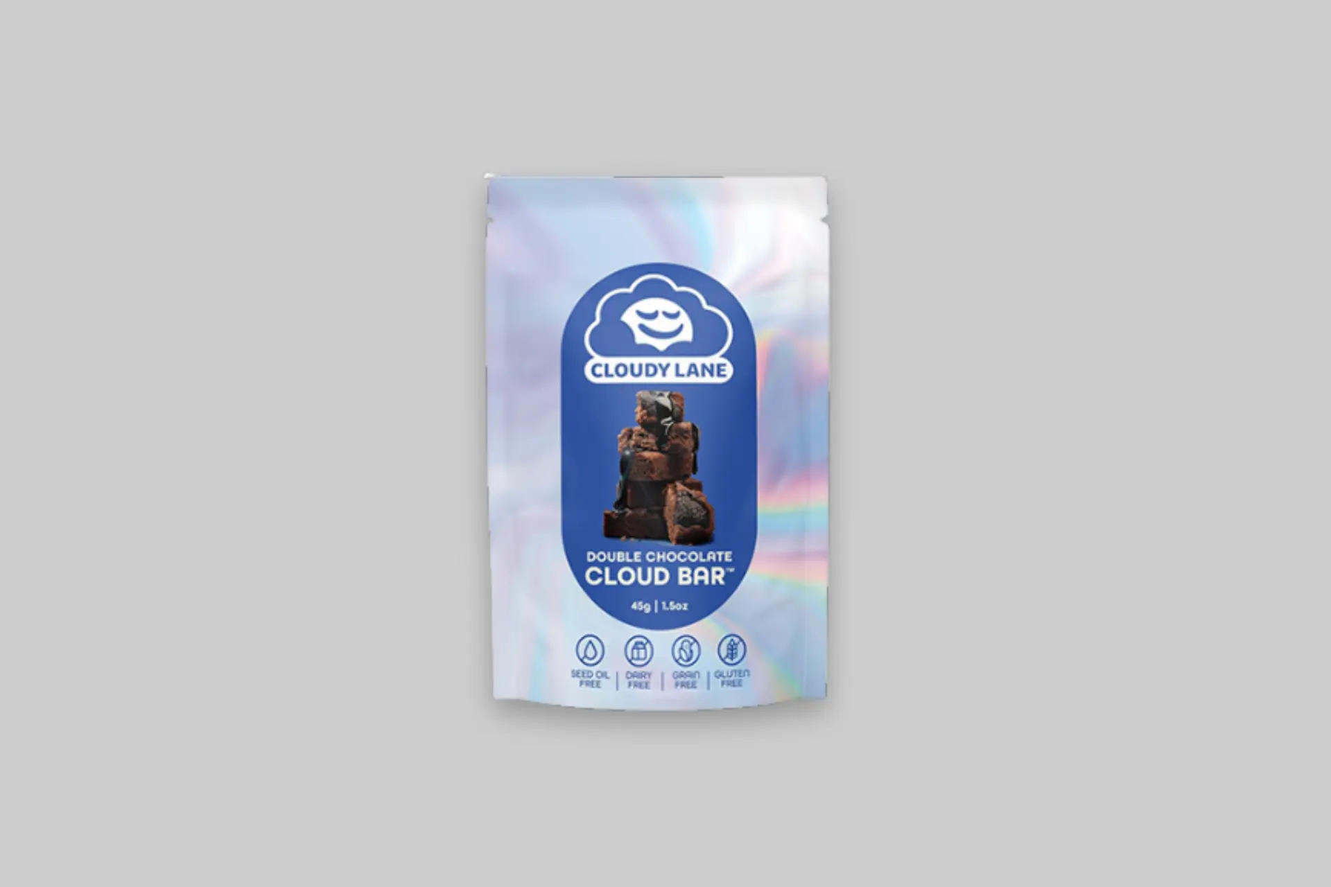A Double Chocolate Cloud Bar from Cloudy Lane in its packaging, showing the moist, deep brown chocolate bar with visible chocolate chunks, alongside the 10-pack box.