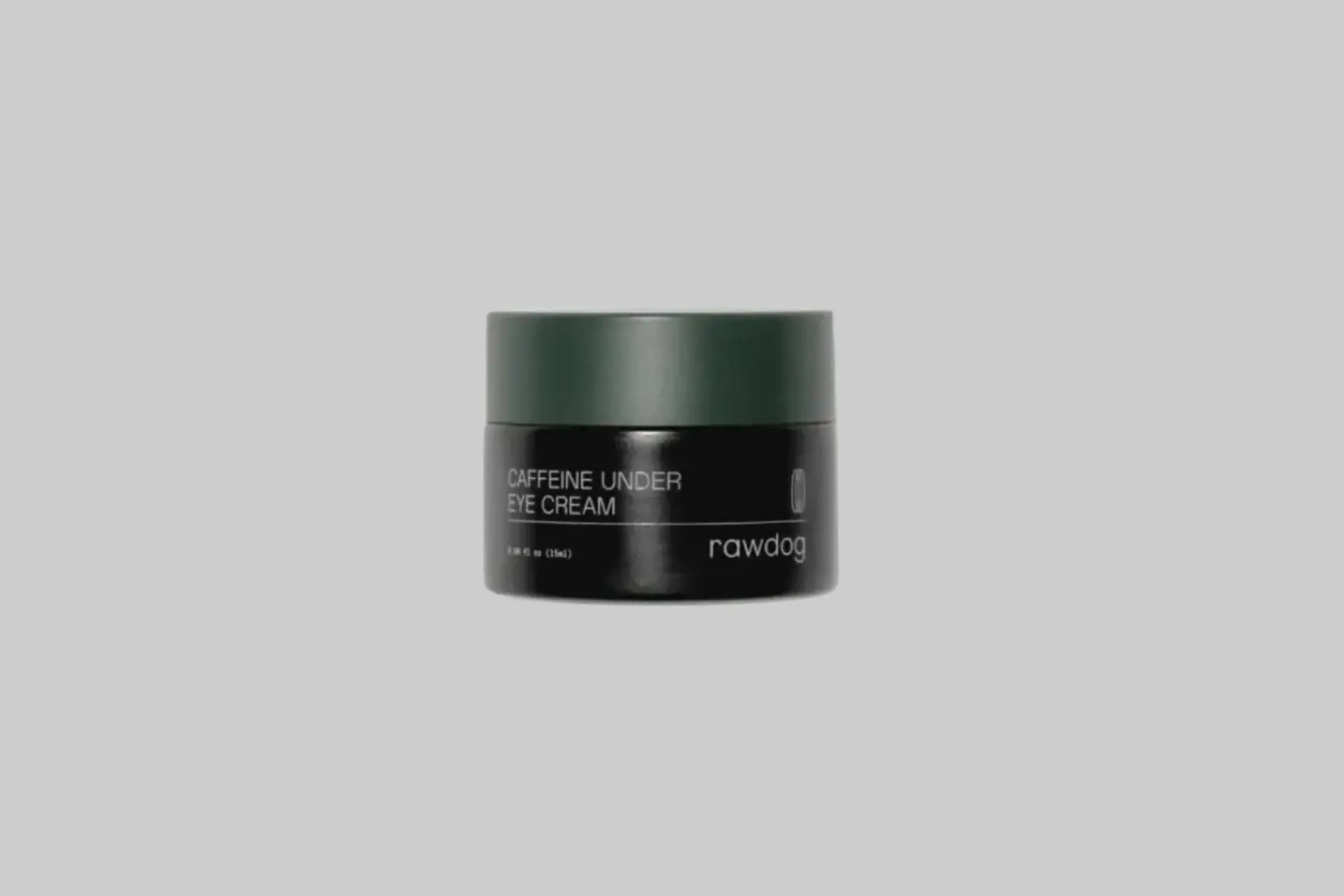 RAWDOG Caffeine Under Eye Cream in a small white jar with black text, shown with a product swatch on a hand revealing its lightweight cream texture.