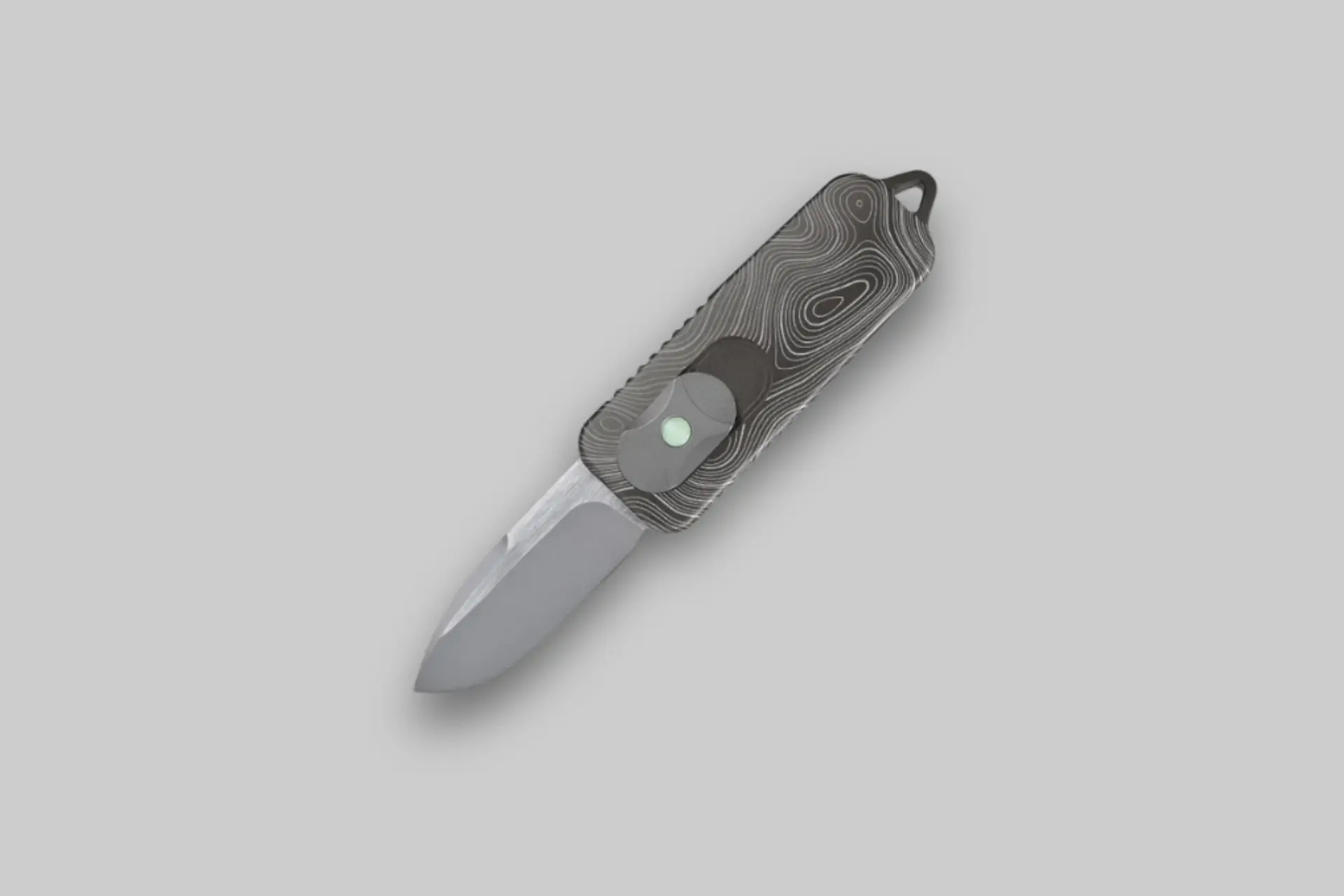 Close-up of the Terrain 365 CAS OTF Topo Edition automatic knife, highlighting the topographic map laser-etched on its handle and the deployed VANAX blade. - Product Review