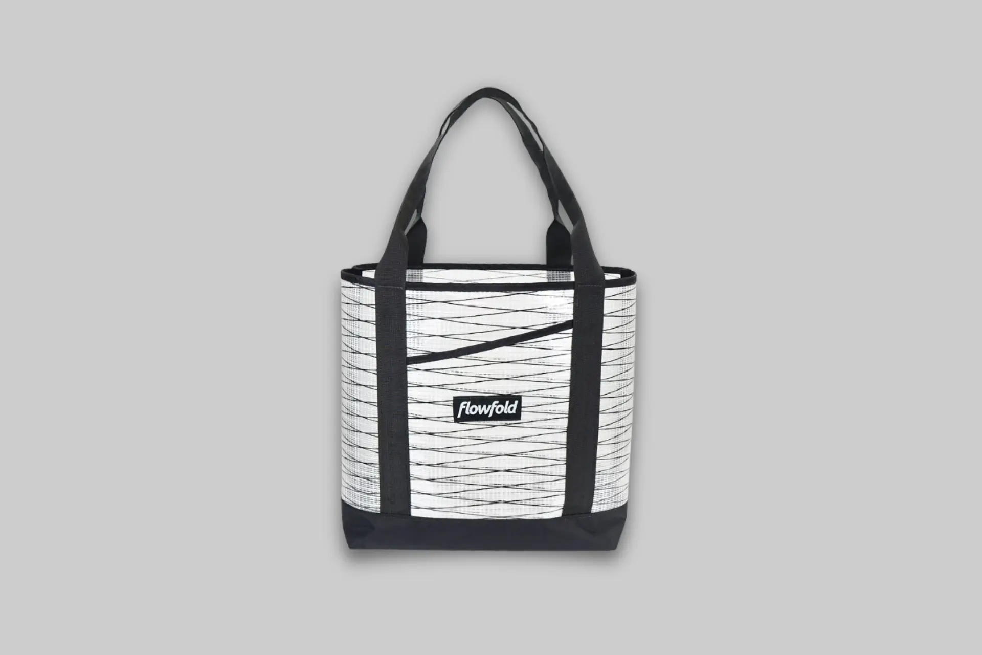 A minimalist Flowfold Recycled Sailcloth Porter Tote 16L in a neutral color, showcasing its texture and simple design. - Product Review