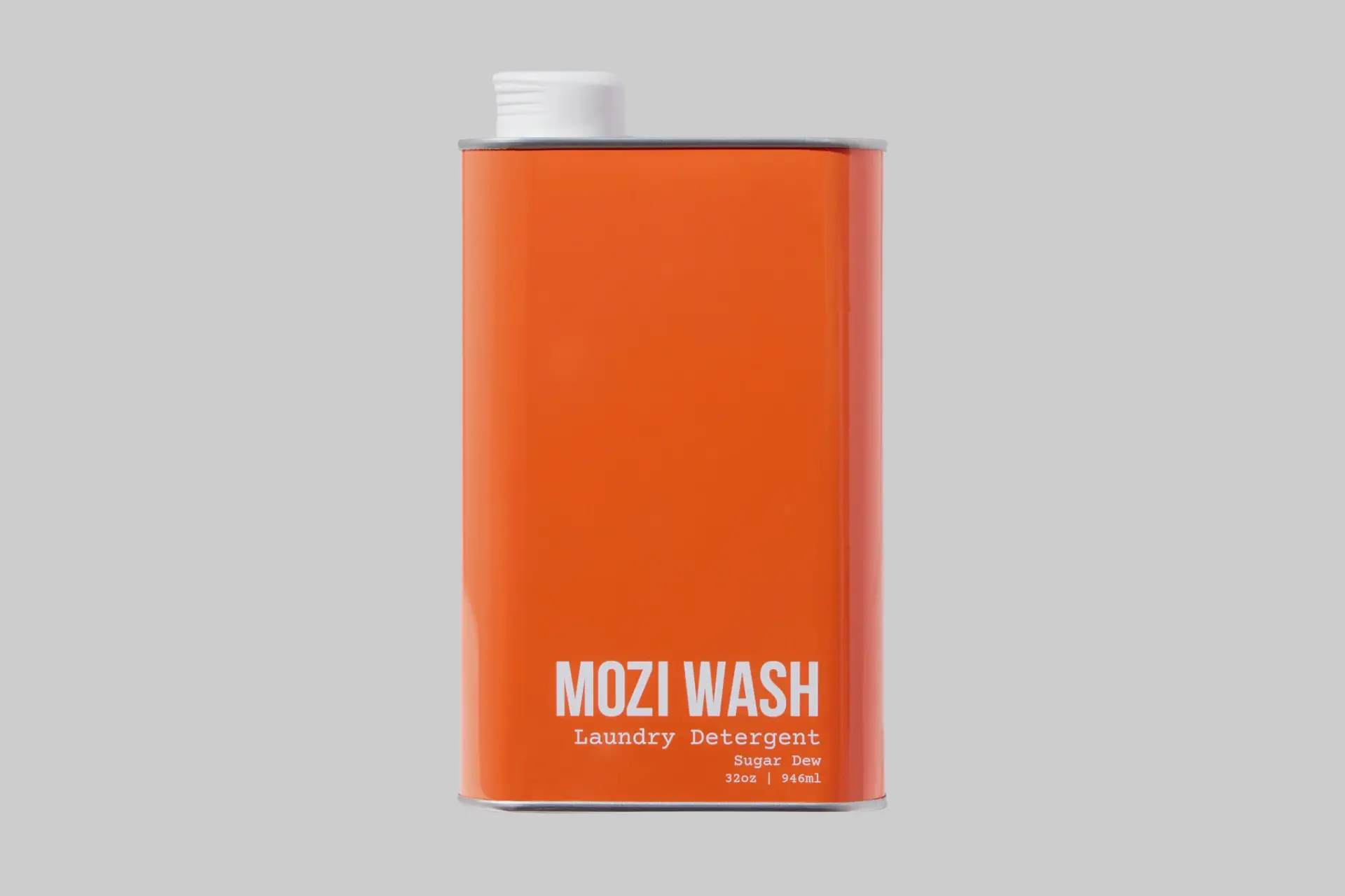 Mozi Wash Sugar Dew laundry detergent in its sleek, recyclable metal bottle, surrounded by tropical fruits and hibiscus flowers. - Product Review