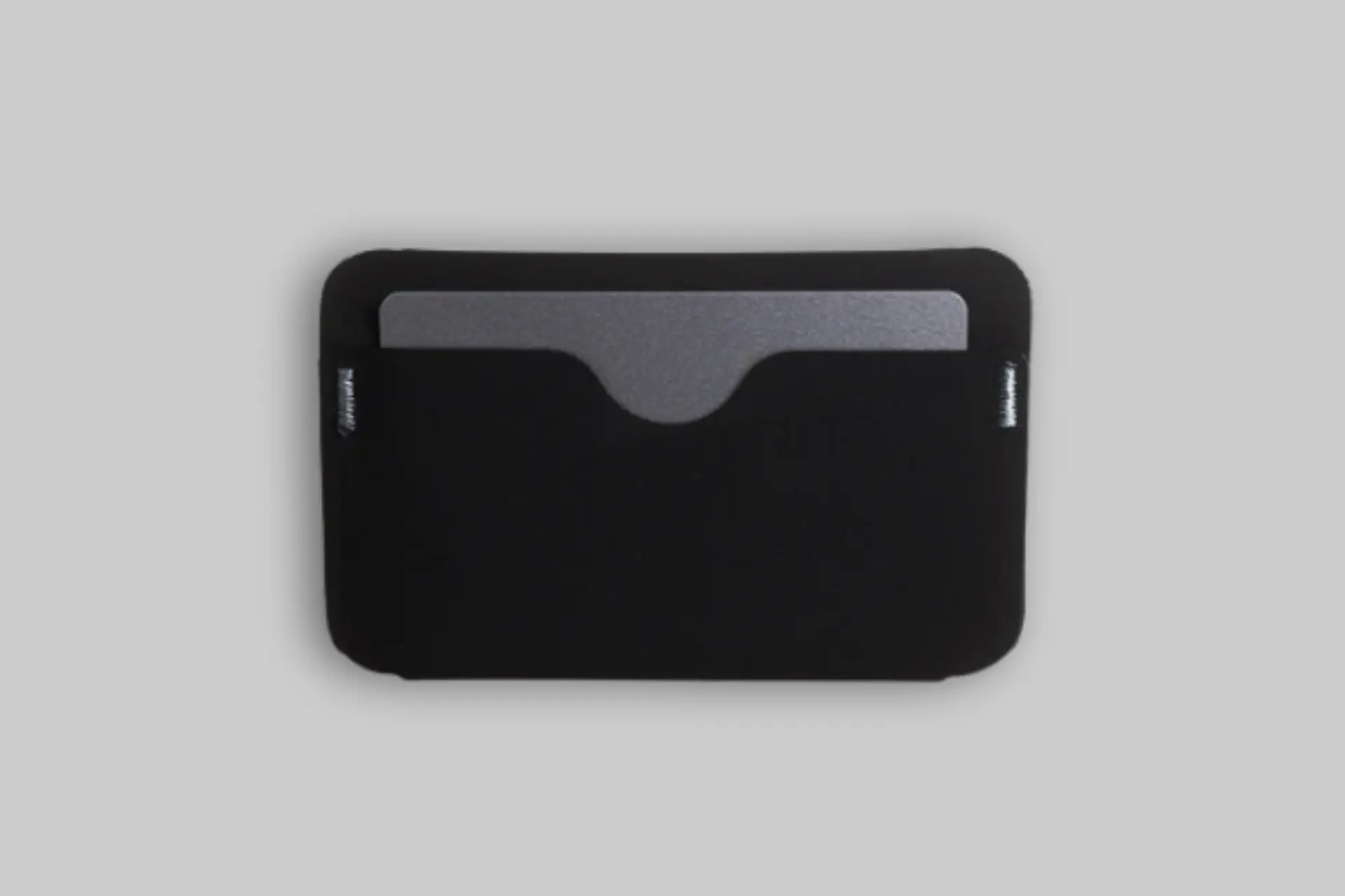 A sleek, matte black Reform RE:01 Coin Sleeve wallet showcasing its magnetic closure and coin pouch with cards and an AirTag inside. - Product Review