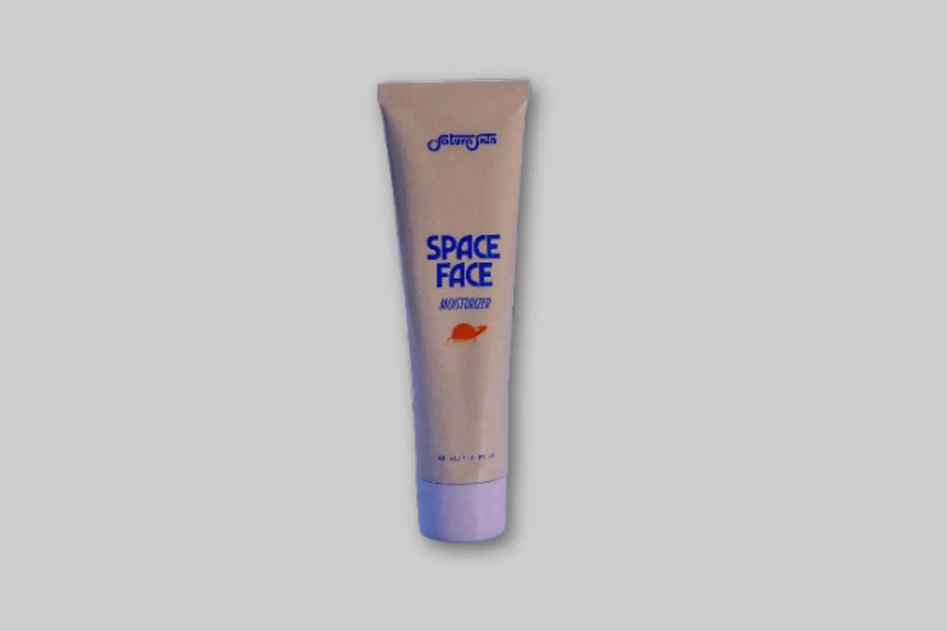 A sleek, silver aluminum tube of Saturn Skin Space Face Moisturizer against a minimalist, cosmic-themed background. - Product Review