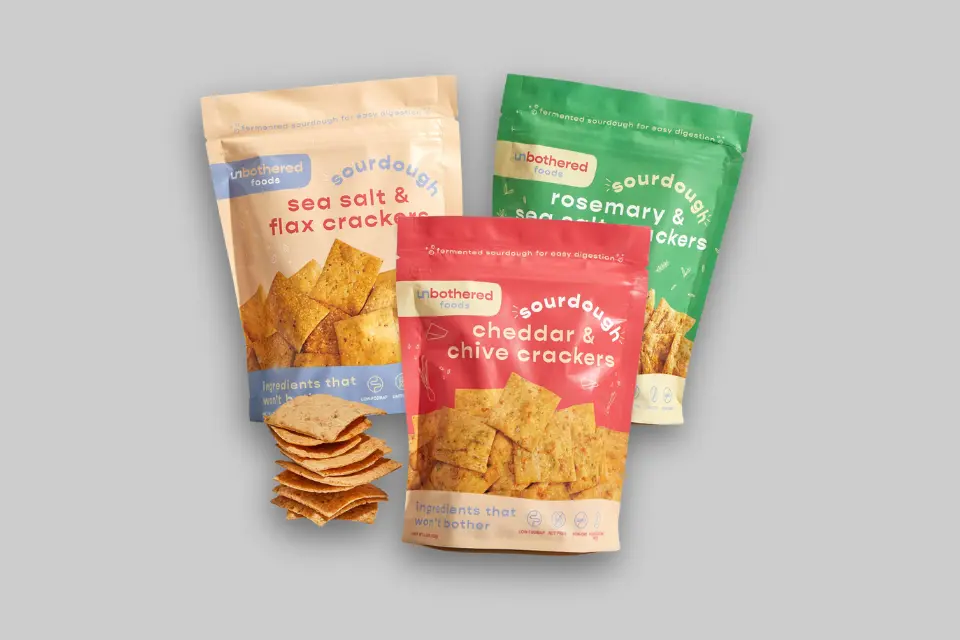 A variety pack of Unbothered Foods sourdough crackers, showcasing three distinct flavor bags arranged appealingly. - Product Review